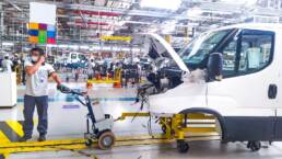 Remolcador M12 arrastrando un veh&iacute;culo en una planta de producci&oacute;n